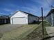 View of the white siding and garage with newly installed gravel driveway at 769 E Pearl St, Whiteland, IN 46184