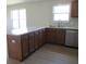 Kitchen island features a double sink, wood cabinets, and luxury vinyl plank flooring at 769 E Pearl St, Whiteland, IN 46184