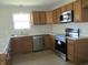 Kitchen with stainless appliances, wood cabinets, and luxury vinyl plank flooring at 769 E Pearl St, Whiteland, IN 46184