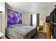Comfortable bedroom with a large bed, a bright yellow mirror, and natural light from the window at 7965 Benjamin Dr, Lawrence, IN 46226