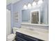 Stylish bathroom with a blue vanity, a large mirror, and modern lighting at 8077 Foxchase Dr, Indianapolis, IN 46256