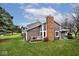 Exterior view of a home featuring a brick chimney and a wooden deck at 8077 Foxchase Dr, Indianapolis, IN 46256