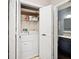 Laundry room with washer, dryer, and shelving, accessible through white double doors at 8077 Foxchase Dr, Indianapolis, IN 46256