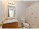 Bathroom with light wood vanity, toilet, and flower patterned shower curtain at 888 Streamside Dr, Greenfield, IN 46140