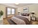 This bedroom includes a large bed with a neutral blanket with matching pillows and artwork at 888 Streamside Dr, Greenfield, IN 46140