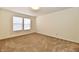 Bright bedroom featuring neutral carpet and white walls, complemented by a window at 888 Streamside Dr, Greenfield, IN 46140
