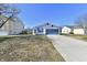 Charming one-story home with blue garage door and well-manicured lawn at 888 Streamside Dr, Greenfield, IN 46140