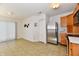 Open kitchen and dining area with stainless steel refrigerator and adjacent pantry at 888 Streamside Dr, Greenfield, IN 46140