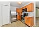 Functional kitchen showcasing wooden cabinetry, stainless steel appliances, and neutral floors at 888 Streamside Dr, Greenfield, IN 46140