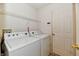 Bright laundry room with white washer, dryer and shelving at 888 Streamside Dr, Greenfield, IN 46140