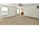 Spacious living room featuring neutral carpet, ceiling fan, and an adjacent kitchen at 888 Streamside Dr, Greenfield, IN 46140
