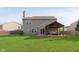Spacious backyard with lush lawn, a covered patio, and partial fence line at 9011 Harrison Run Dr, Indianapolis, IN 46256