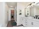Bright bathroom featuring double vanity with marble countertop, modern fixtures, and a walk-in closet at 9011 Harrison Run Dr, Indianapolis, IN 46256