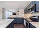 Well-lit kitchen featuring stainless steel appliances, an island, and dark cabinetry at 9011 Harrison Run Dr, Indianapolis, IN 46256