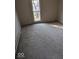 Small empty bedroom with a window offering light and a view, neutral carpet and a radiator at 9278 S Geneva Rd, Flat Rock, IN 47234