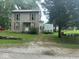 Two-story home features a metal roof, vertical siding, shutters and a small porch in an established neighborhood at 9278 S Geneva Rd, Flat Rock, IN 47234