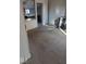 Neutral carpet leads from the living room, which has a free-standing fireplace, toward the kitchen at 9278 S Geneva Rd, Flat Rock, IN 47234