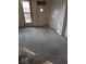 Empty living room with neutral carpet, a window with a view and some damage to the walls and trim at 9278 S Geneva Rd, Flat Rock, IN 47234