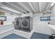 Basement laundry room with modern washer and dryer on a platform and open ceiling at 9531 Prospect St, Indianapolis, IN 46239