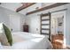 Bedroom featuring wood beams, closet doors and an ensuite bathroom with a glass enclosed shower at 9531 Prospect St, Indianapolis, IN 46239
