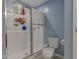 Modern bathroom with a glass-enclosed shower, toilet, and blue accent wall at 1012 Balto Dr, Shelbyville, IN 46176