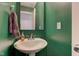 Chic powder room with a pedestal sink, green walls, and modern towel rack at 1012 Balto Dr, Shelbyville, IN 46176