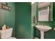 Stylish powder room with dark green walls, a floating shelf, and modern fixtures at 1012 Balto Dr, Shelbyville, IN 46176
