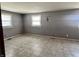 Bedroom featuring tiled floors, neutral gray walls, and natural light from the two windows at 10131 Nassau Ln, Indianapolis, IN 46229