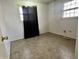 Modest bedroom features neutral walls, flooring, and two windows, one with a black curtain at 10131 Nassau Ln, Indianapolis, IN 46229