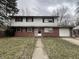 Classic two-story home with brick and siding exterior, complemented by a well-kept lawn and paved walkway at 10131 Nassau Ln, Indianapolis, IN 46229