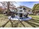 A spacious backyard featuring a fire pit with Adirondack chairs and water feature at 10415 Charter Oaks, Carmel, IN 46032