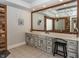 Rustic bathroom with a distressed vanity, large mirror, and wood-paneled accent wall at 10415 Charter Oaks, Carmel, IN 46032