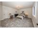 Inviting bedroom offers a cozy ambiance with hardwood floors, a chandelier, and ample natural light from the window at 10415 Charter Oaks, Carmel, IN 46032