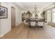 Elegant dining room boasts a decorative chandelier, designer wallpaper, and light-filled windows at 10415 Charter Oaks, Carmel, IN 46032