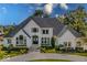 Stunning white home featuring lush landscaping, a circular drive, and beautiful architectural details at 10415 Charter Oaks, Carmel, IN 46032