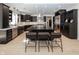 Modern kitchen features sleek black cabinetry, stainless steel appliances, large island, and hardwood flooring at 10415 Charter Oaks, Carmel, IN 46032
