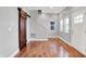 The living room has hardwood floors, natural light from multiple windows, and a rustic sliding barn door at 1056 Hosbrook St, Indianapolis, IN 46203