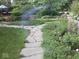 Lush garden featuring a stone path, verdant plants, and ambient lighting at 10614 Winterwood, Carmel, IN 46032