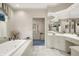 Bright bathroom featuring marble tile, a soaking tub, and a window at 10614 Winterwood, Carmel, IN 46032