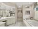 Bright bathroom featuring marble tile, large tub, and a window at 10614 Winterwood, Carmel, IN 46032