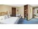 Comfortable carpeted bedroom with patterned wallpaper and brass bed with a blue comforter at 10614 Winterwood, Carmel, IN 46032