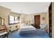 Bedroom with patterned wallpaper, blue carpet, and a brass bed with a light blue comforter at 10614 Winterwood, Carmel, IN 46032