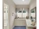 Bright dressing room with window and blue accents and white cabinets at 10614 Winterwood, Carmel, IN 46032