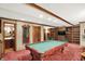 Game room with billiard table, with bar stools and a washroom in the background at 10614 Winterwood, Carmel, IN 46032