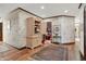 Hallway with floral wallpaper leads to other rooms including a view of the library and living room at 10614 Winterwood, Carmel, IN 46032