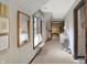 A long and well-lit hallway leads to other rooms with a window and vintage style decor at 10614 Winterwood, Carmel, IN 46032
