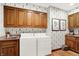 Functional laundry room with wood cabinets, sink, and convenient washer and dryer setup at 10614 Winterwood, Carmel, IN 46032