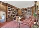 Grand library featuring custom wood bookshelves, a cozy sitting area, and warm lighting, ideal for relaxation and reading at 10614 Winterwood, Carmel, IN 46032