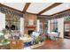 Inviting living room featuring a brick fireplace, hardwood floors, and sun-filled windows offering scenic views at 10614 Winterwood, Carmel, IN 46032