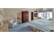 Cozy main bedroom features blue carpeting, a floral armchair, a large window with seating, and a wood wardrobe at 10614 Winterwood, Carmel, IN 46032